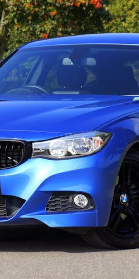 Modern blue luxury car parked by a scenic roadside on a sunny day. Stylish design.